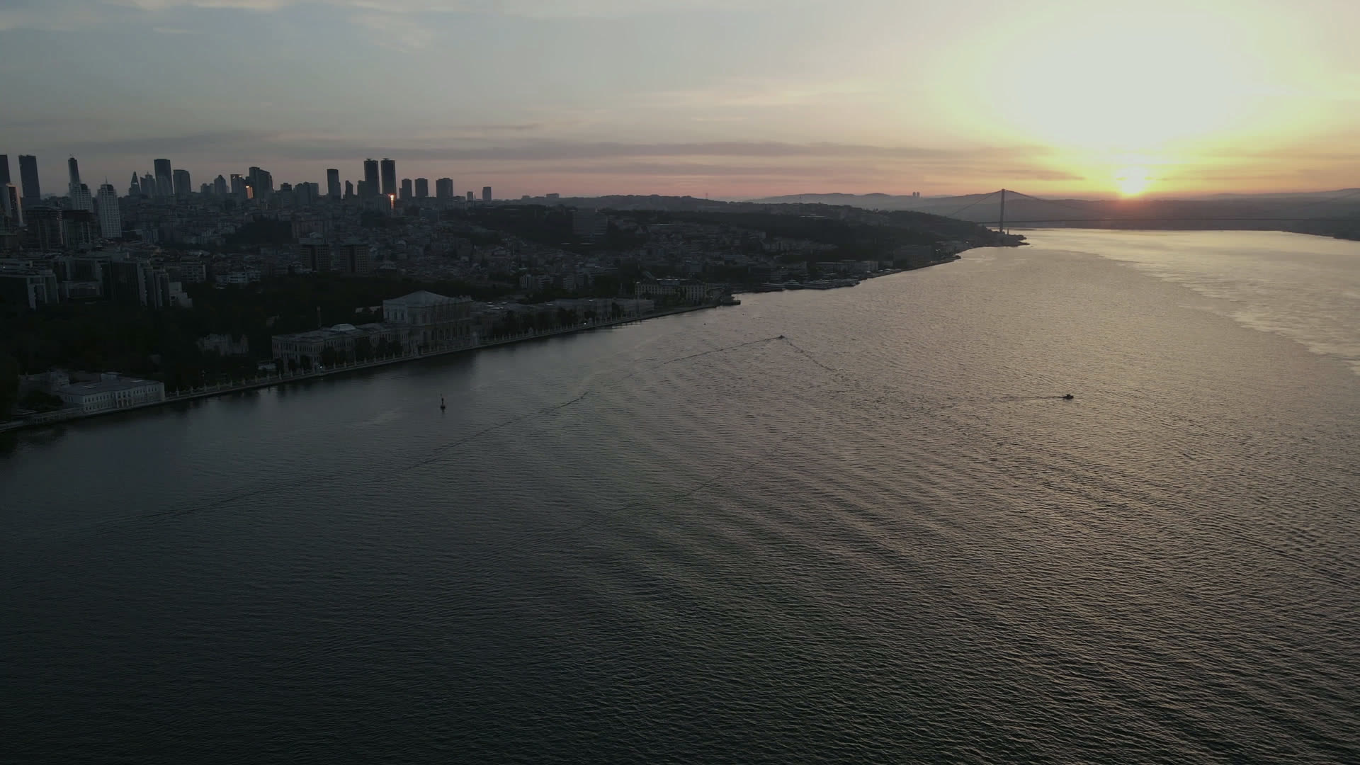 The Bosphorus at sunset; the Beşiktaş–Ortaköy shoreline with the city skyline behind, from the air.