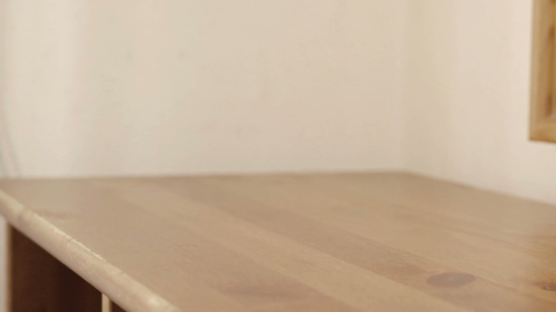 A hand setting a bunch of keys down on a wooden table.